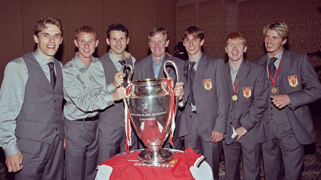 David Beckham with other members of Manchester United posing with the Champions League trophy.