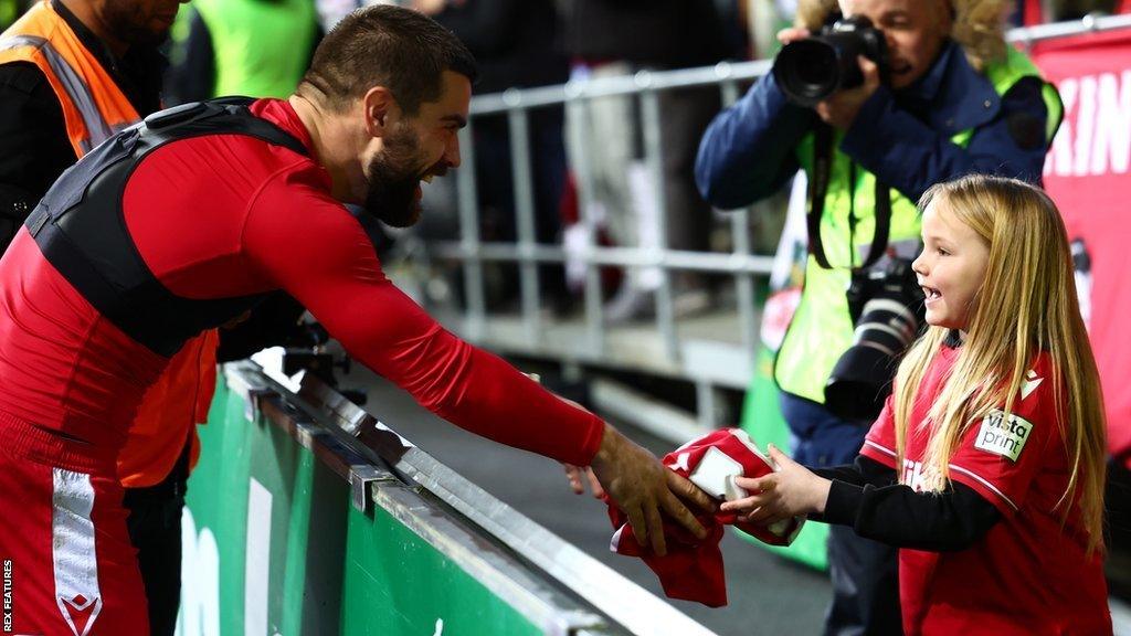 Midfielder Elliot Lee hands his shirt to a young fan after Wrexham's FA Cup win at Coventry on 7 January 2023