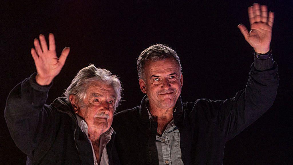 Former President of Uruguay José Mujica and presidential candidate for the Frente Amplio party Yamandu Orsi greet their supporters at the closing campaign rally in April 2024 in Montevideo, Uruguay. (Photo by Ernesto Ryan/Getty Images)