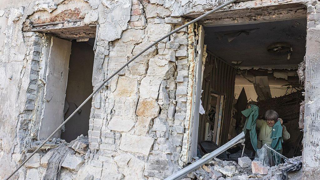An elderly woman is pictured in her home, which was badly damaged after a Russian attack on a residential building in the city of Druzhkivka, Ukraine. 