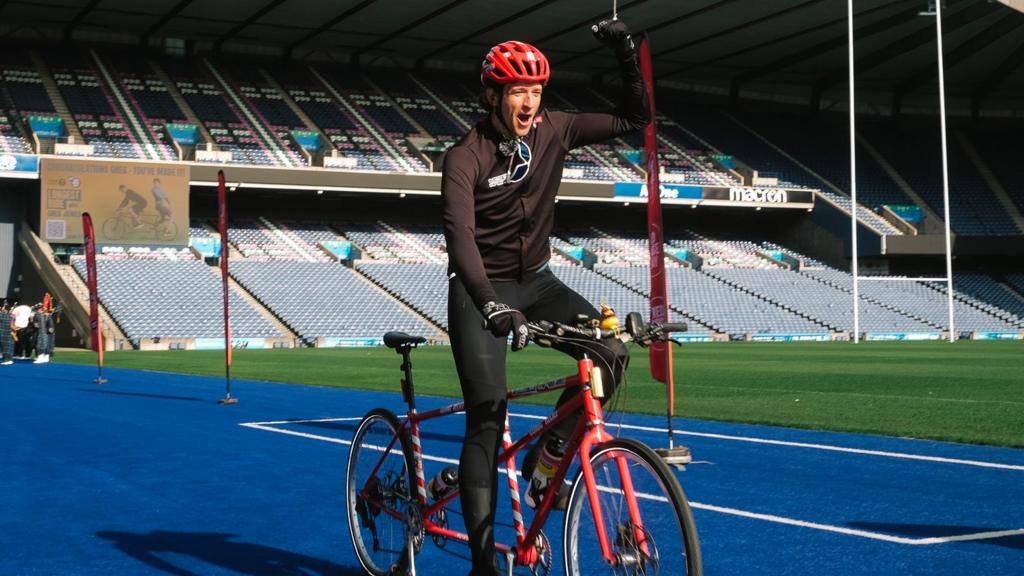 Greg James celebrates finishing his Longest Ride challenge for Comic Relief in Murrayfield stadium, Edinburgh
