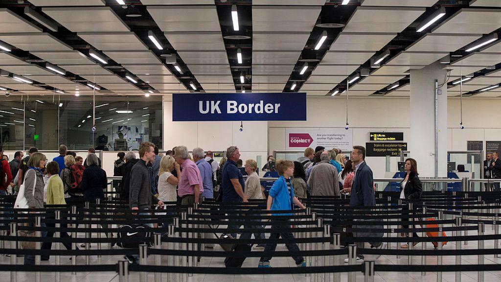 Travellers queueing to clear UK border security at an airport