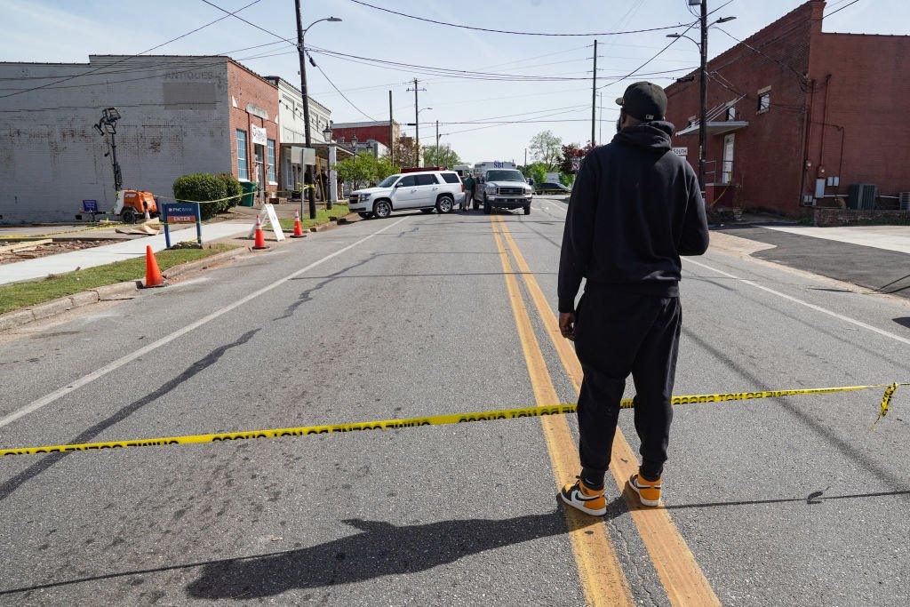 DJ Keenan Cooper stands behind police tape