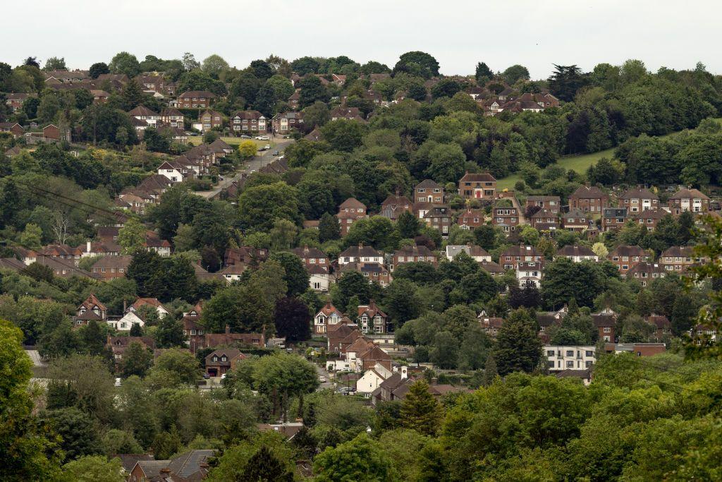 A picture of houses on the side of a hill in Wycombe, there are lots of houses in this picture and also lots of trees.