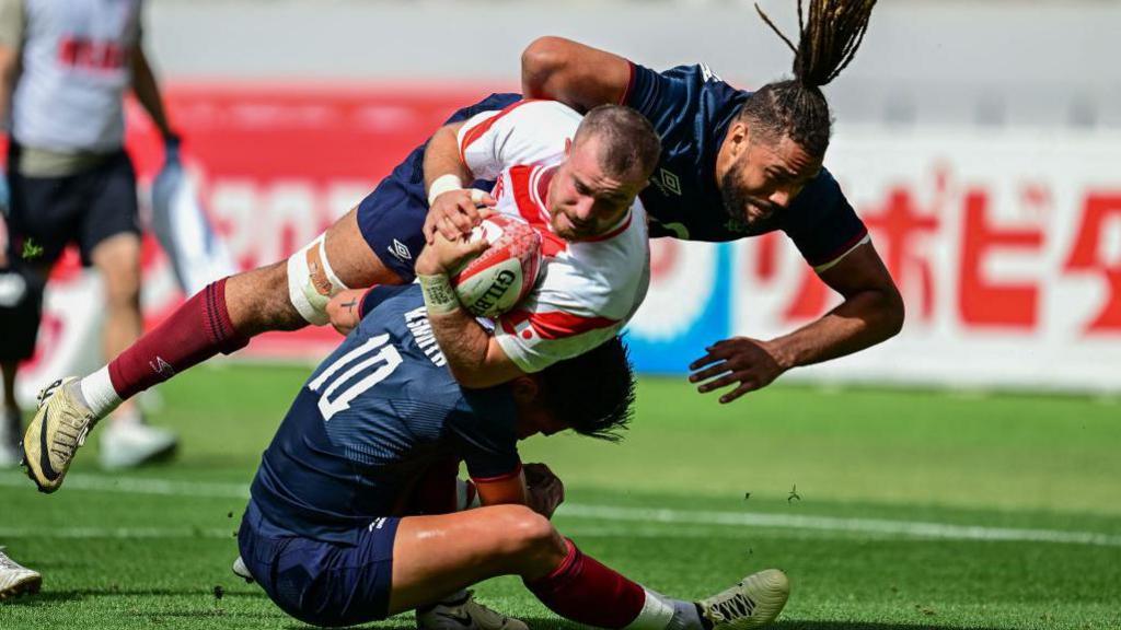 Chandler Cunningham-South helps Marcus Smith stop a Japan attackutes