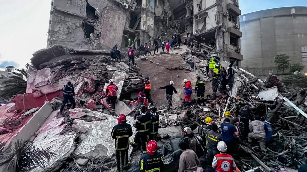 First responders search for missing people under the rubble of a partially destroyed residential building following an Israeli air strike.