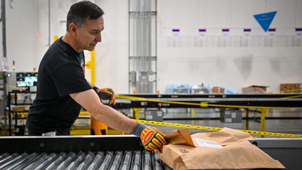 An Amazon employee works to fulfill same-day orders during Cyber Monday, one of the company's busiest days of the year at an Amazon fulfillment center on December 2, 2024 in Orlando, Florida.