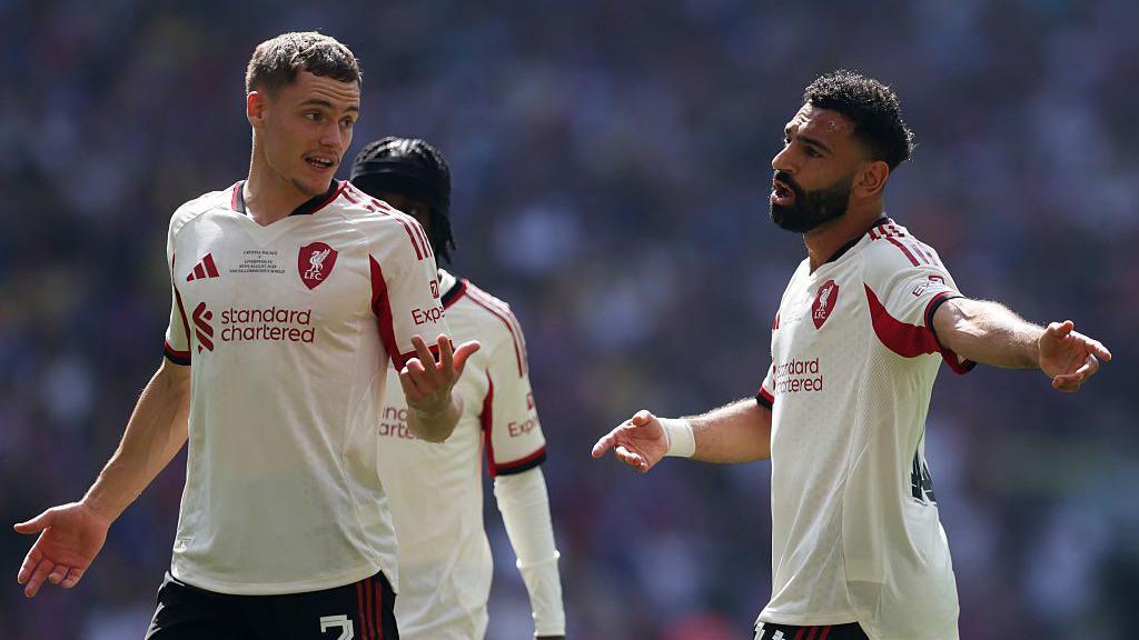 Mohamed Salah of Liverpool speaks with Florian Wirtz during the Community Shield