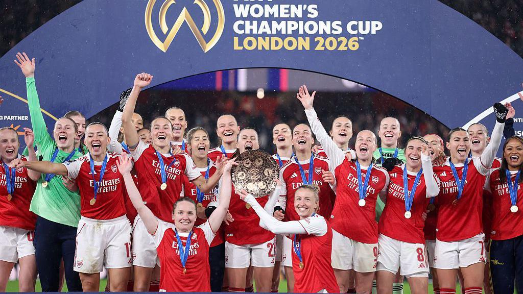 Arsenal players celebrating with the Women's Champions Cup Trophy.