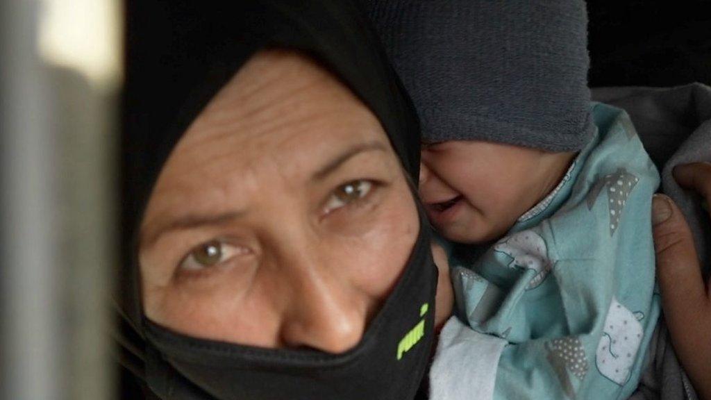 An Afghan woman holding a child