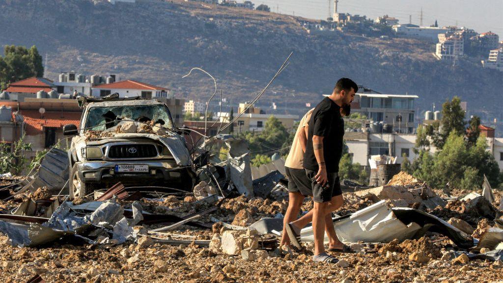  People inspect the site of an Israeli air strike in Jiyeh along the highway linking Beirut to the southern city of Sidon on September 25, 2024