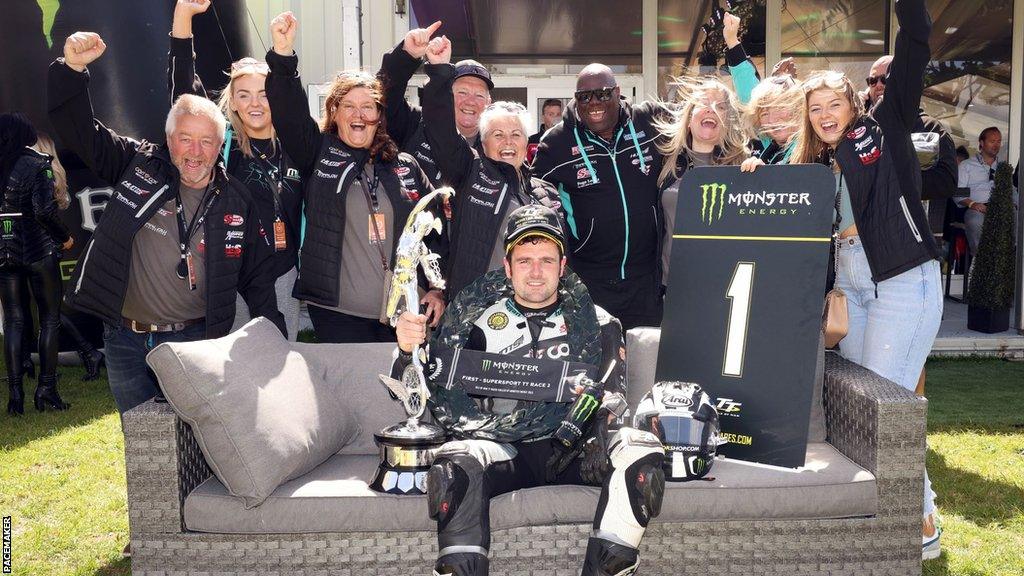 Michael Dunlop celebrates his second Supersport success in 2022 with members of his team