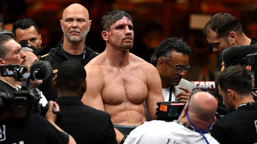 Rico Verhoeven is surrounded by people in the ring following his defeat by Oleksandr Usyk