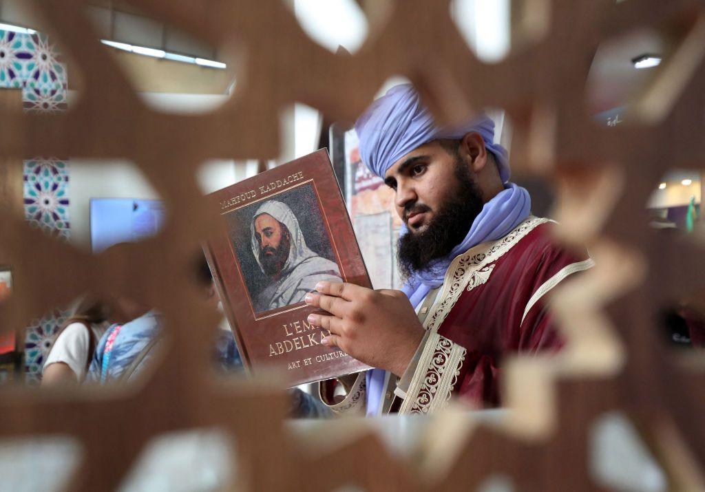 A man checks looks at  book as he visits the 27th international book fair in Algiers.)