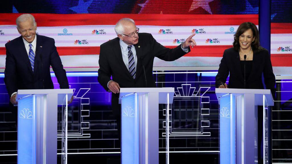 Harris seen at a presidential primary debate in 2019, alongside Bernie Sanders and Joe Biden