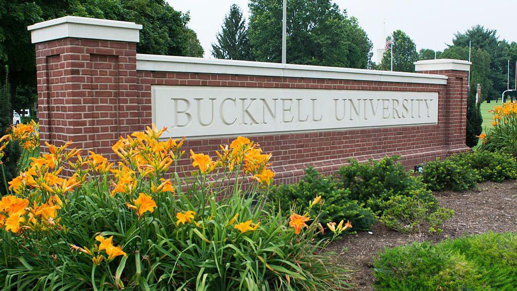 A sign, in brick and stone near a flowerbed, reads 'Bucknell University'