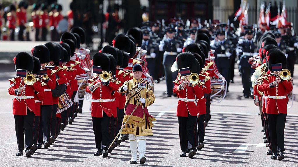 Musicians march in a procession ahead of king's birthday parade