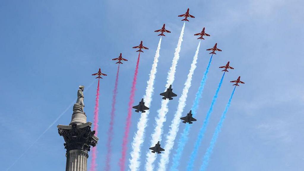 red arrows streak red, blue and white across the sky following flypast.