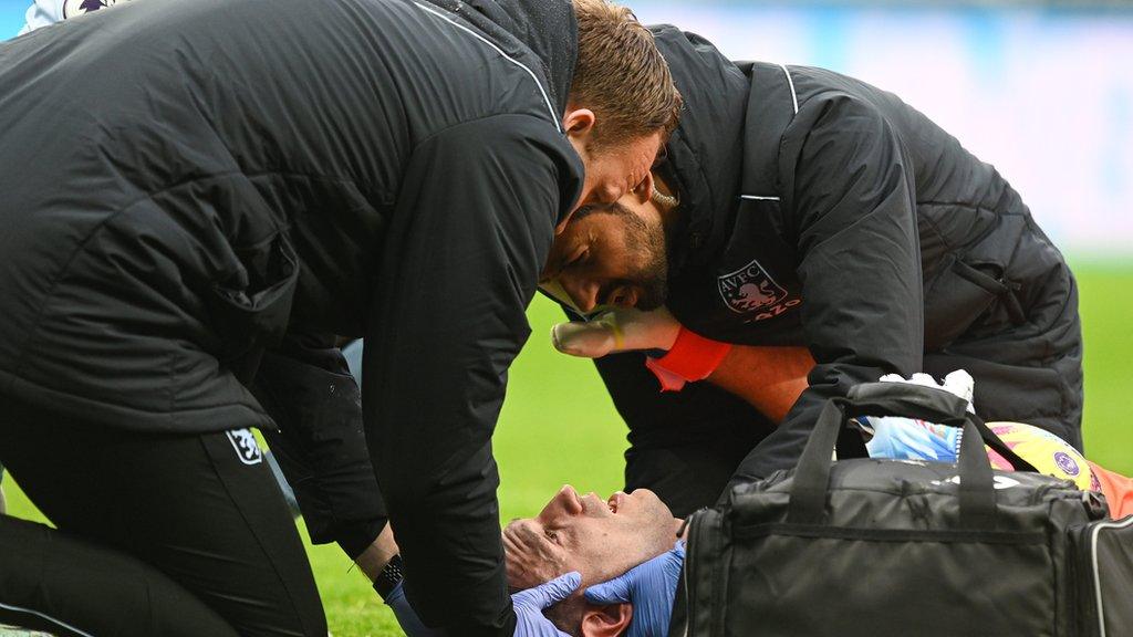 Aston Villa goalkeeper Emiliano Martinez being treated for a suspected concussion