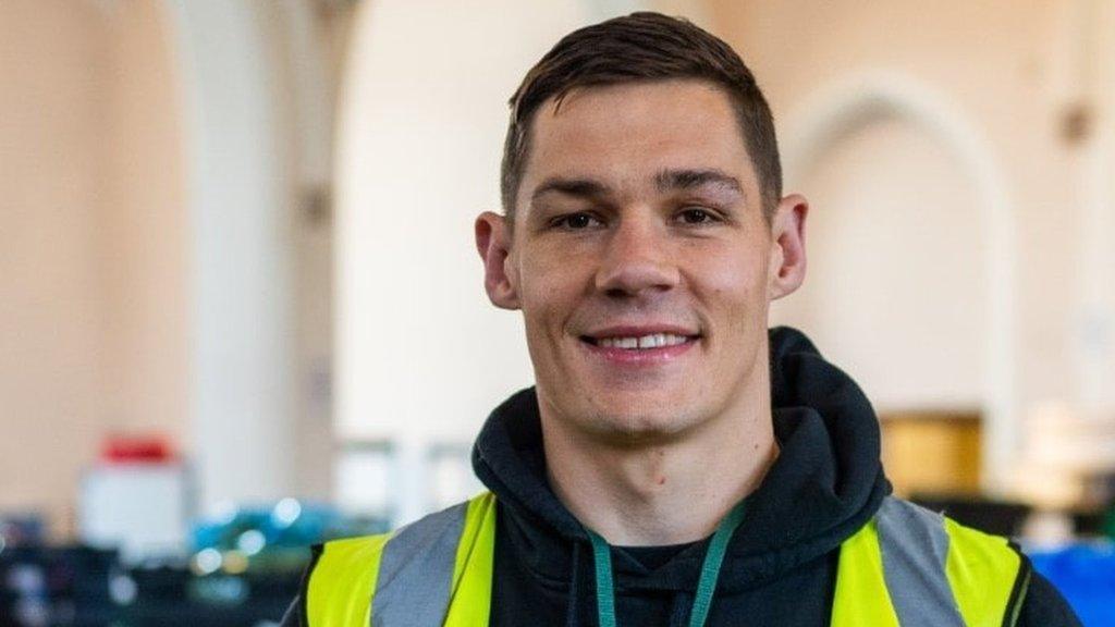 Chris Billiam-Smith wearing a hi-vis vest and sorting food at Bournemouth Foodbank warehouse