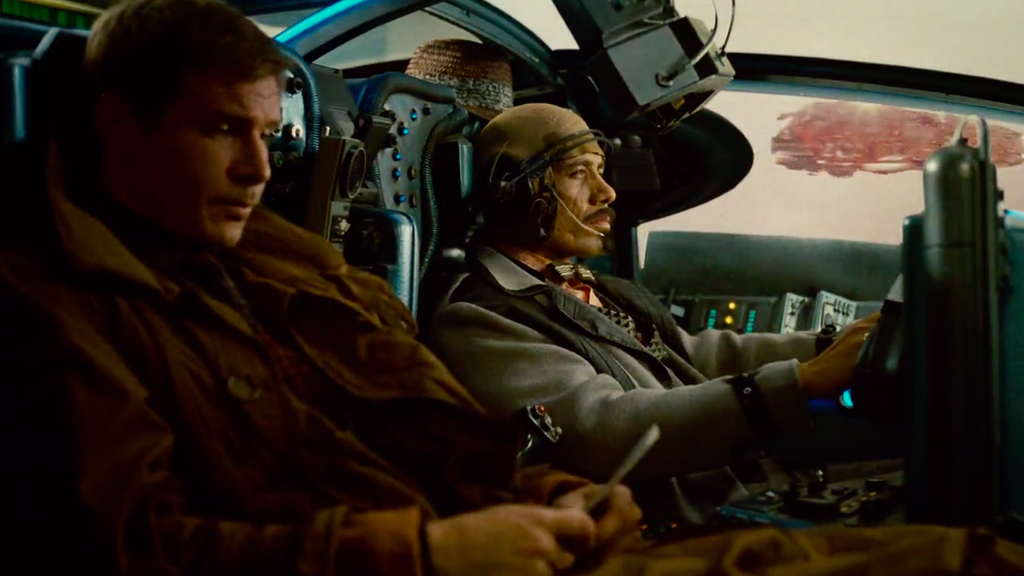 Deckard sits with officer Gaff in a flying car