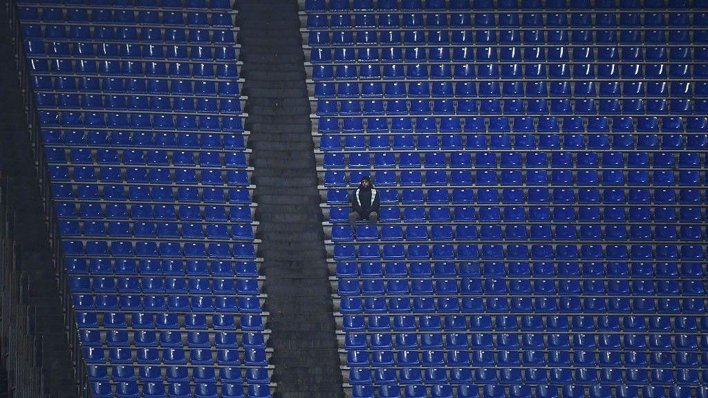 A solitary Lazio fan sits surrounded by empty seats