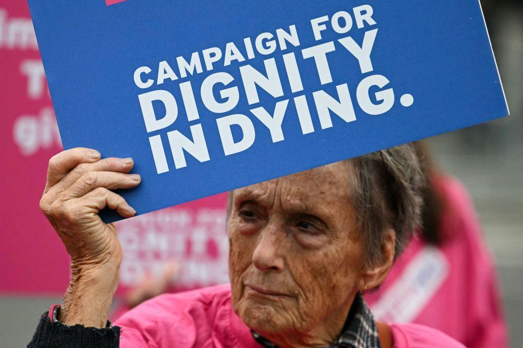 A campaigner from "Dignity in Dying" holds a placard during a demonstration outside The Palace of Westminster, home to the Houses of Parliament