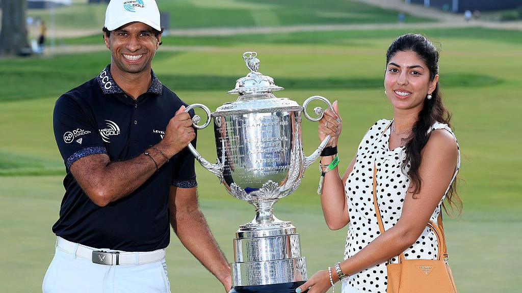 Aaron Rai holds the Wanamaker Trophy with his wife