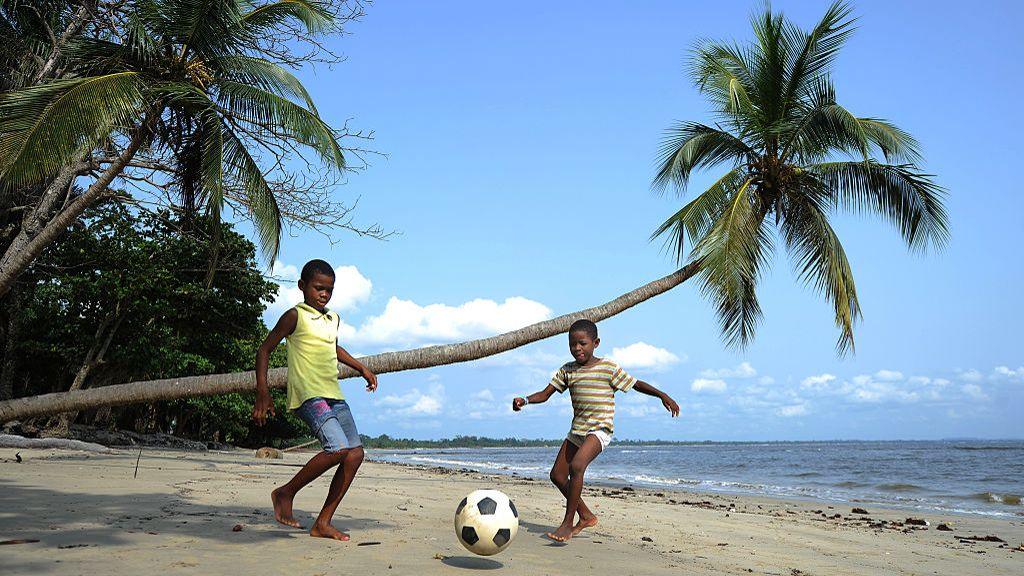 Boys play football on a beach near Libreville in 2012.