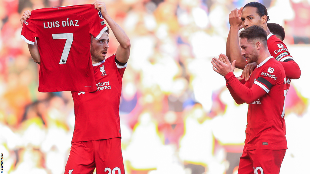 Liverpool's players applaud as Diogo Jota celebrates his goal by holding up a shirt with the name of team-mate Luis Diaz on it