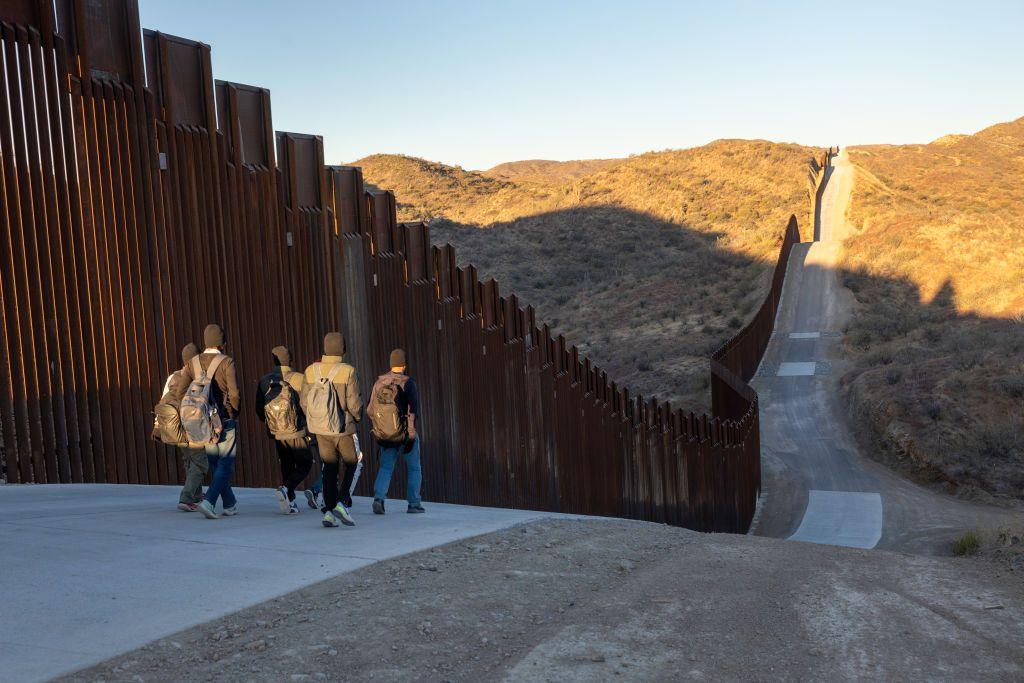 Immigrants from India walk next to the Trump-built U.S.-Mexico border fence after crossing into Arizona on January 19, 2025 near Sasabe, Arizona. 