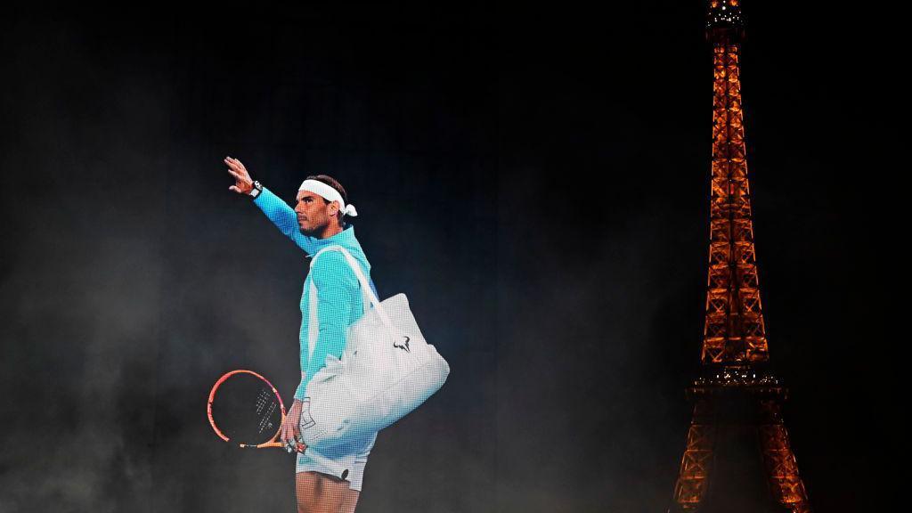 An image of Rafael Nadal is projected into the night sky in Paris, with the Eiffel Tower in the background