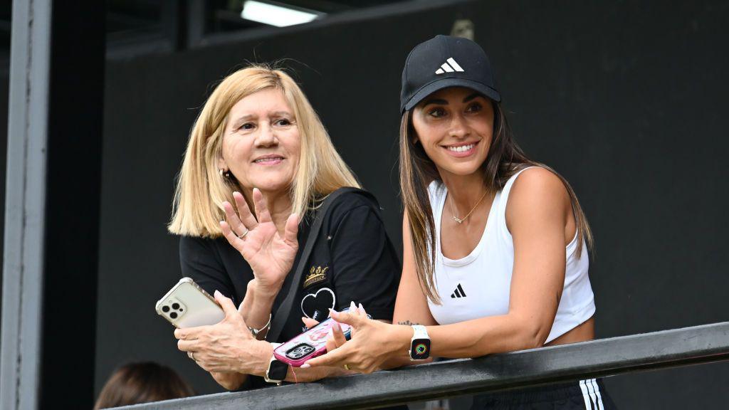 Celia Messi (left) and Antonela Roccuzzo (right) lean on a barrier