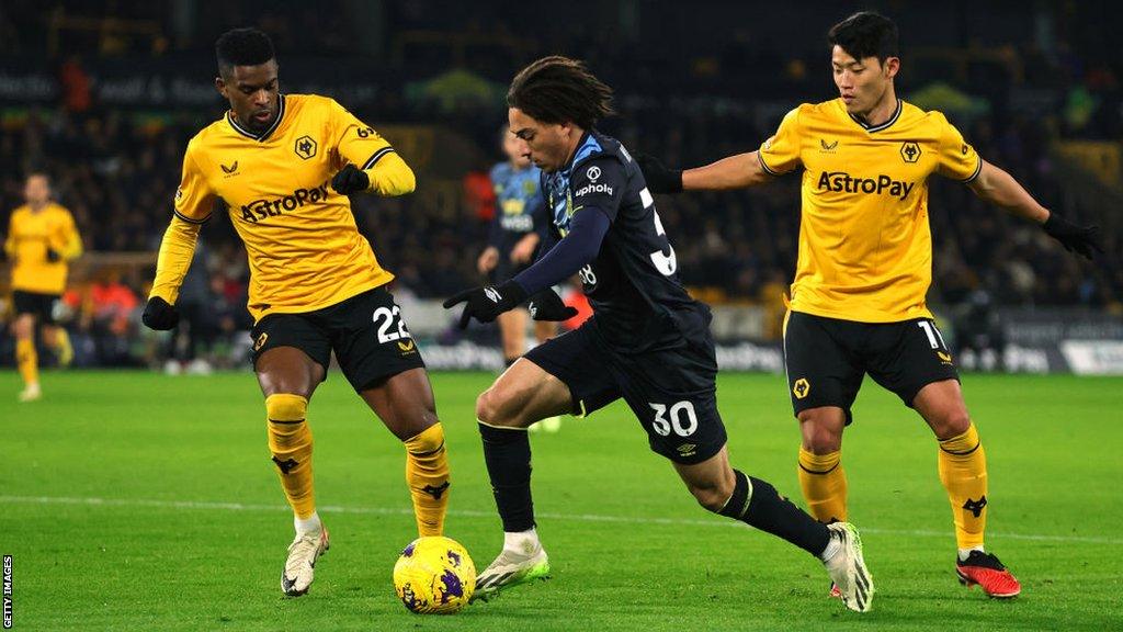 Luca Koleosho of Burnley controls the ball whilst under pressure from Nelson Semedo and Hwang Hee-Chan of Wolves