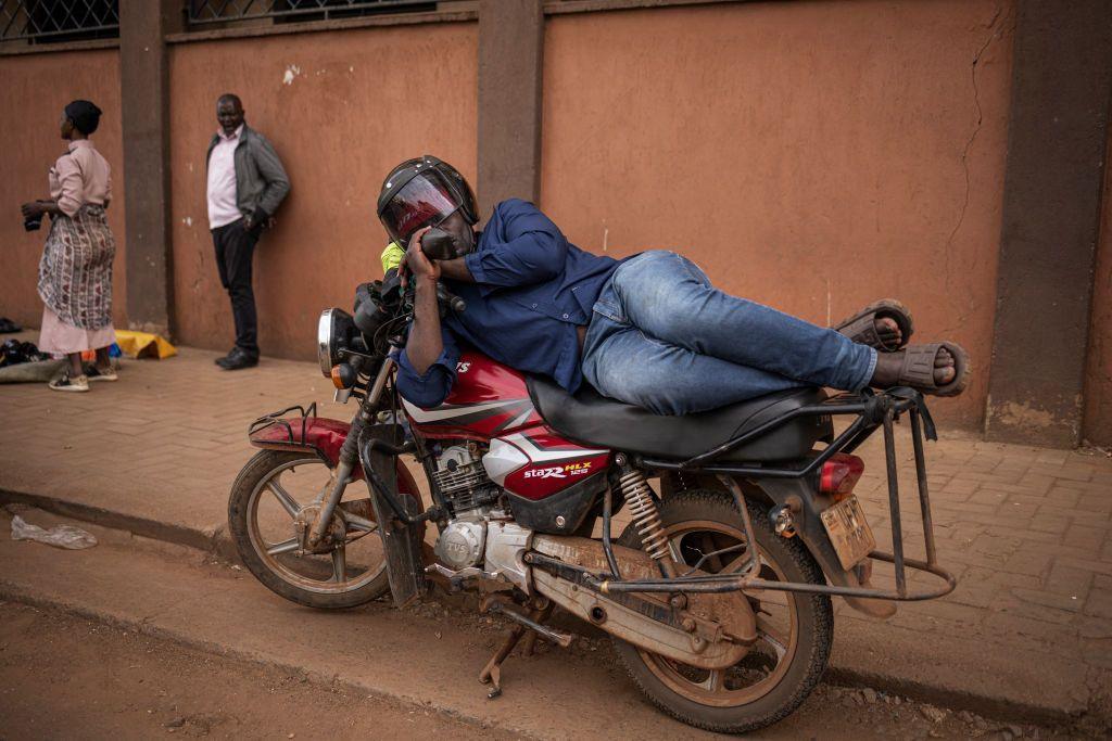 A motorcycle driver sleeps on his vehicle in the streets of Kampala, Uganda - Friday 15 November 2024