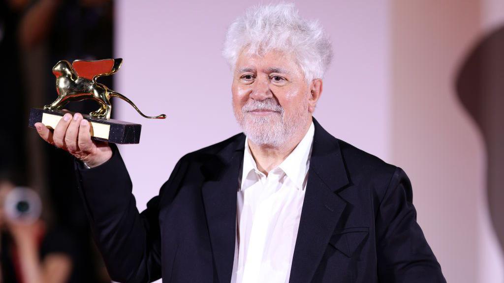 Pedro Almodovar poses with the Golden Lion Award