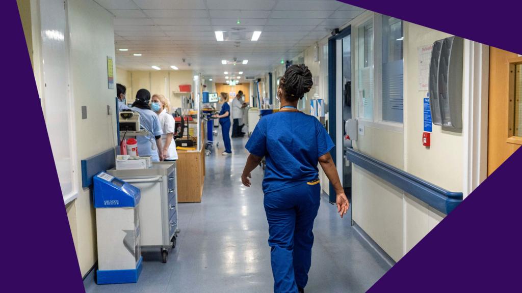 A nurse walks down a corridor in an NHS hospital