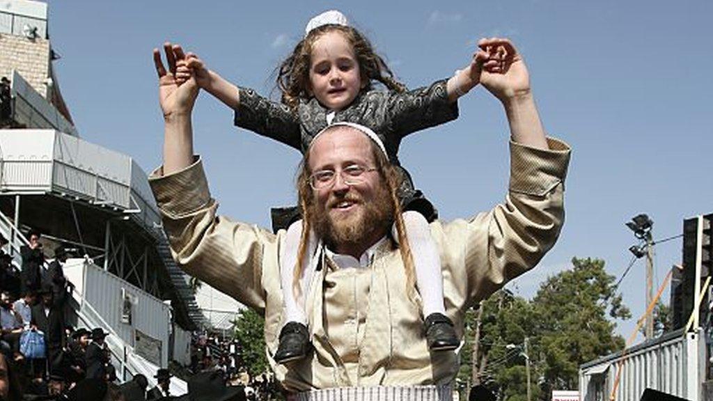 Jewish man with child on his shoulders celebrating Lag B'Omer