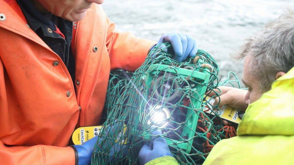 Two fishermen holding camera technology