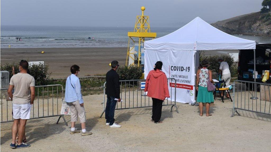 People wait to be tested at a mobile test centre on a beach in western France,