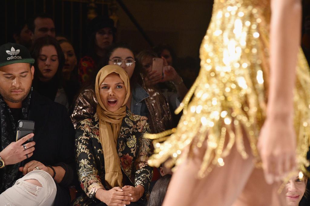 Halima Aden watching a model wearing Sherri Hill designs