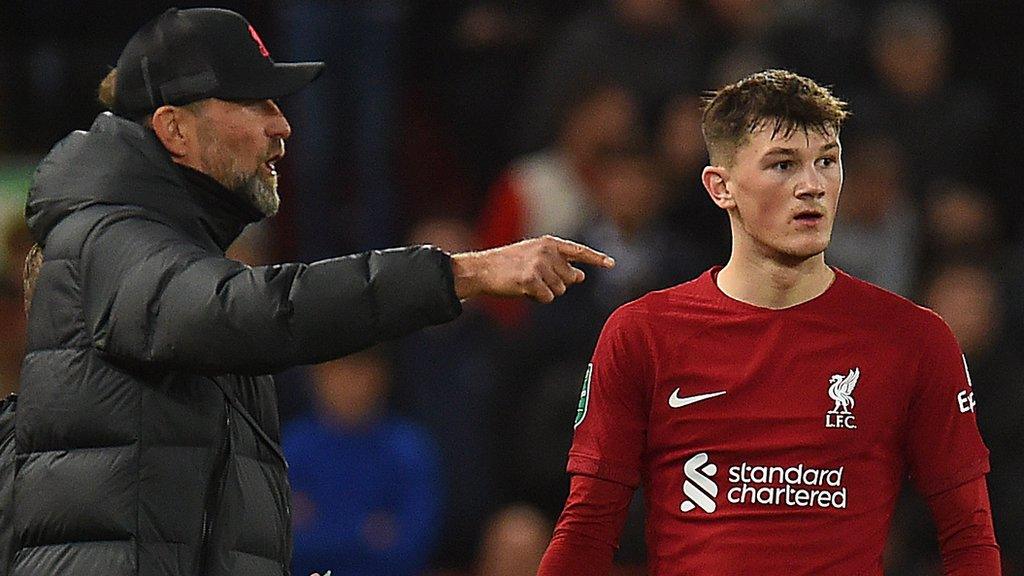 Liverpool manager Jurgen Klopp speaks to Calvin Ramsay on the touchline during a match