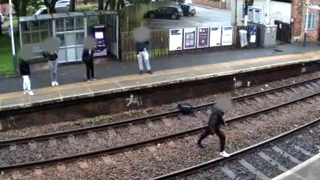 A still from the CCTV which shows a child on the railway line