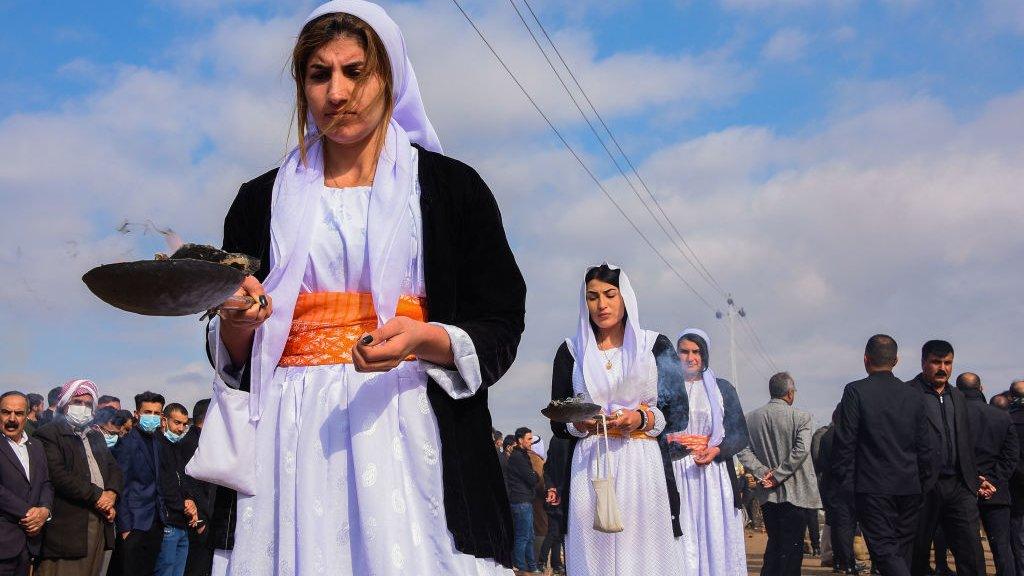 Women burn incense during a procession at the mass funeral in Kocho on 6 February 2021