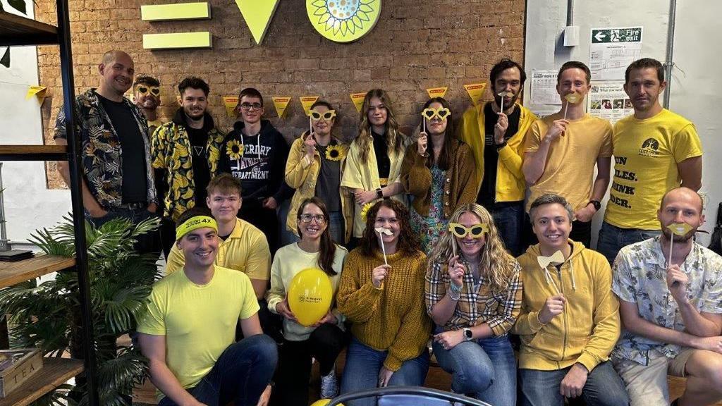 A group of people dressed in bright yellow clothing helping to raise money for the charity.