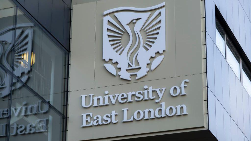 Exterior of building with the University of East London sign and logo