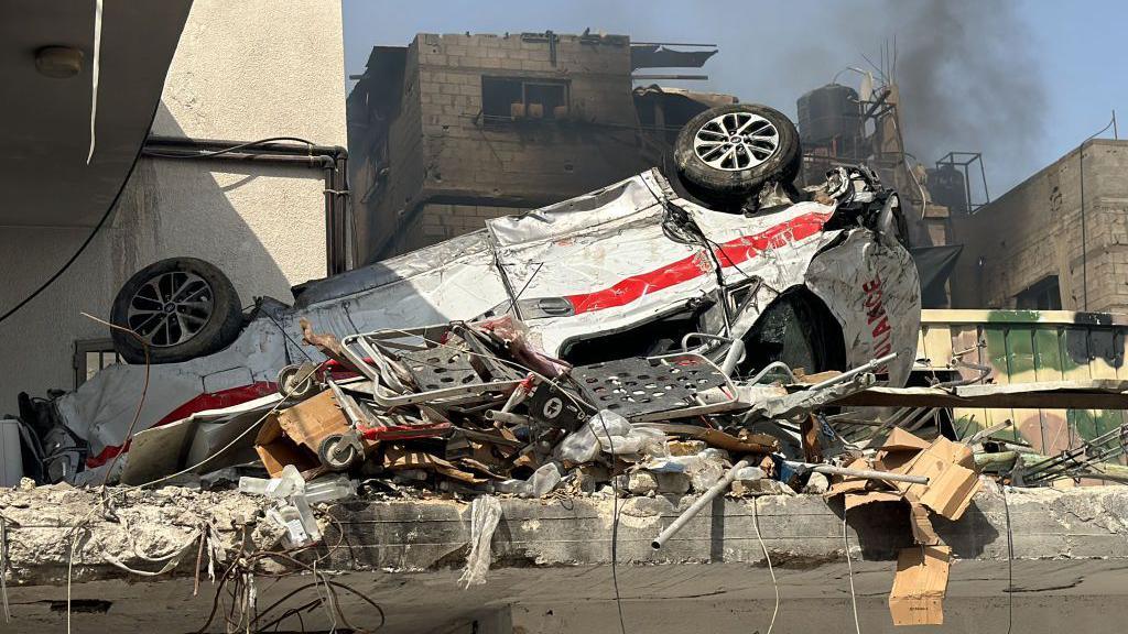 File photo showing a damaged ambulance lying upside down outside Kamal Adwan hospital in Beit Lahia, northern Gaza (26 October 2024)