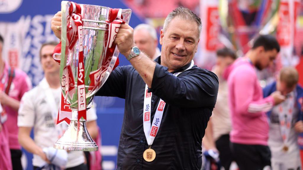 Scott Lindsey holds the League Two play-off final trophy aloft