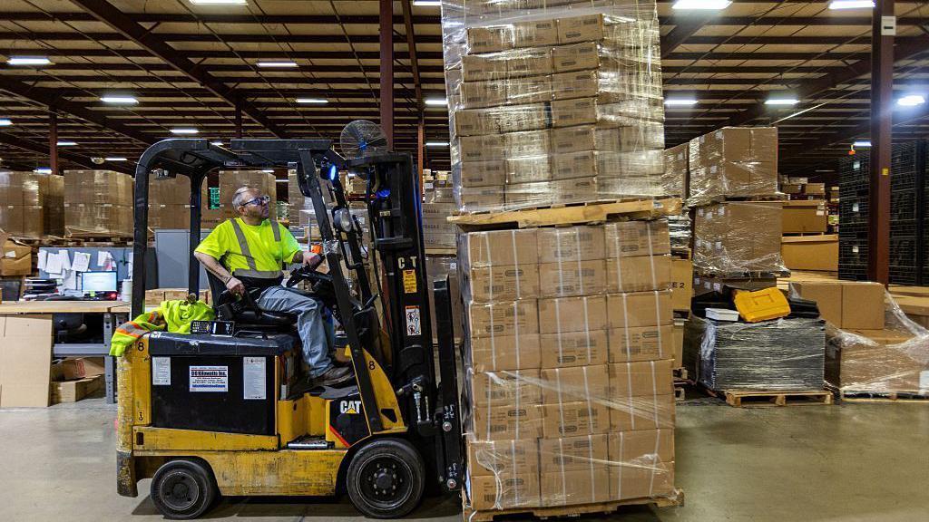 A person in a yellow reflective vest mans a forklift piled high with boxes of toys at the Duncan Toy Company in the firm's warehouse in Columbus, Indiana, on April 16, 2025.