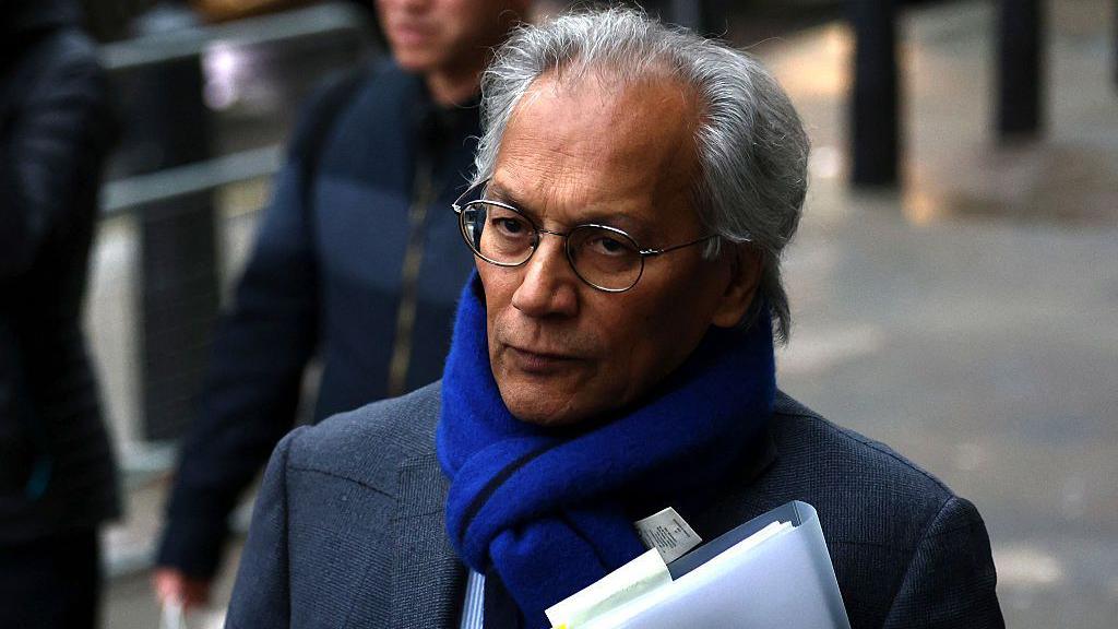 BBC chair Samir Shah walking down a street carrying a file